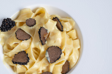 Dish of delicious italian pasta tagliatelle with truffle mushroom chips