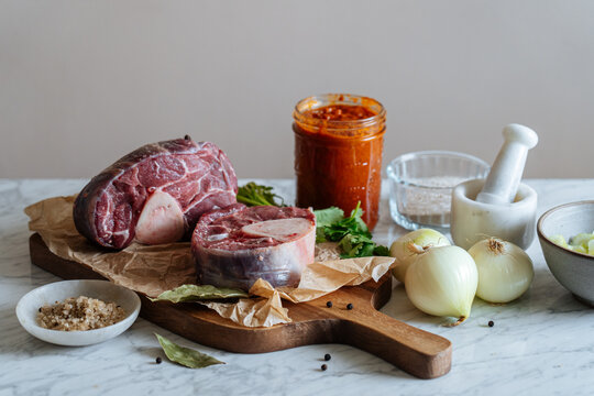 Fresh veal shank and greenery on cutting board