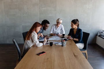 Confident multiethnic employees discussing project a meeting