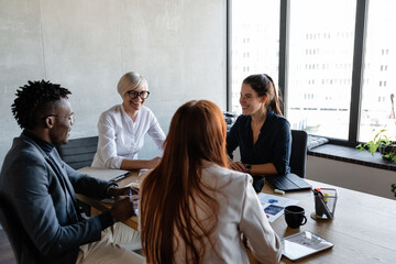 Cheerful multiethnic employees in light modern conference room