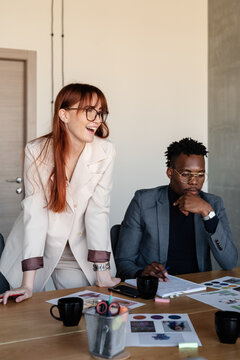 Confident businesswoman sharing ideas with diverse colleagues at meeting