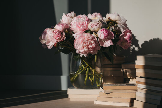 Pink peonies and stacks of books