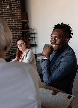 Joyful diverse colleagues chatting in office