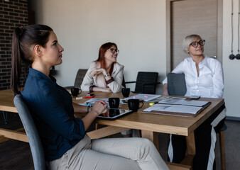 Attentive female employees listening to presentation in conference room