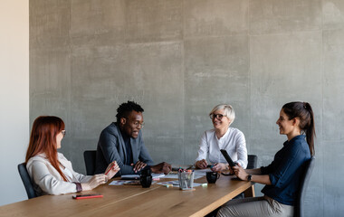 Friendly multiethnic coworkers discussing ideas on meeting