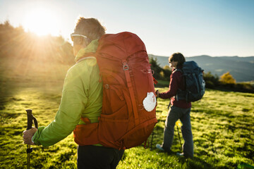 Couple of pilgrims walking along the hill at sunset in Saint James Way