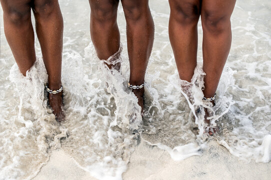 Women legs barefoot in a sandy beach
