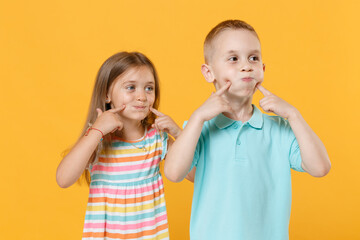 Little couple boy girl 5-6 years old in blue pink clothes shirt dress have fun isolated on yellow...