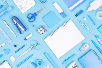 Assorted office and school white and blue stationery and notepad on blue monochrome background. Flat lay knolling with copy space for back to school or education and craft concept. Alarm clock