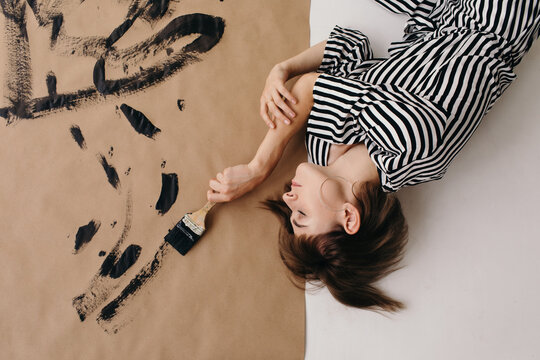Peaceful female artist painting on craft paper