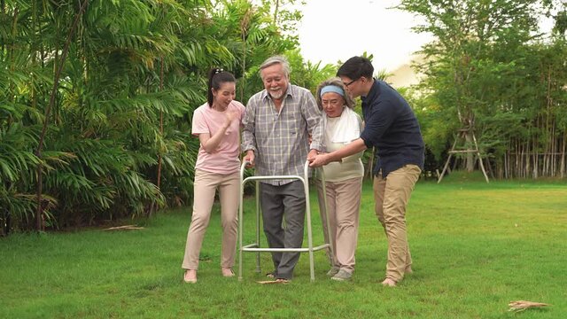 The old man was walking with a walker in the backyard, with a family with a wife, daughter and son to support, until he could walk on his own without a walker to help with. Asian family theme that Ver