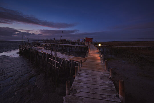 Sunset landscape of artisanal fishing boats in the old wooden pier.
