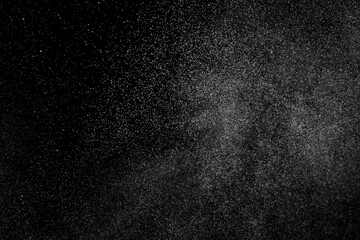 Abstract splashes of water on black background. Freeze motion of white particles. Rain, snow overlay texture.