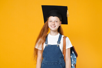 Young redhead school teen girl 12-13 years old in white t-shirt denim uniform graduation cap...