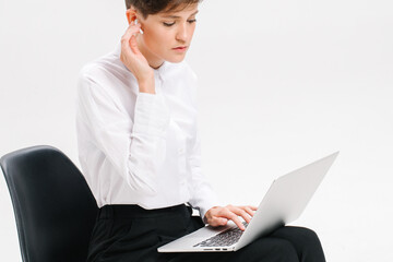 Portrait of a businesswoman using laptop on the office chair isolated on a white background