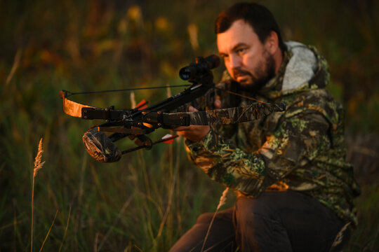 Adult man hunting with a recurved crossbow in the forest on an autumn day.