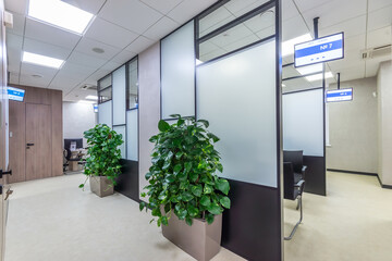 Modern cubicle office with high  black and white glass panels  and digital signages