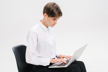 Portrait of a businesswoman using laptop on the office chair isolated on a white background