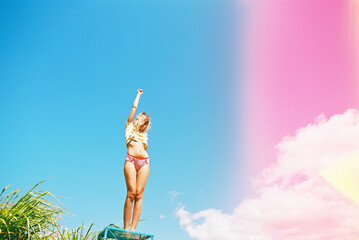 Blonde beautiful woman against bright blue sky in underwear and bra and striped tee