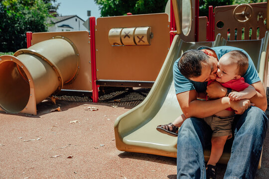 Father Holds Son on Playground