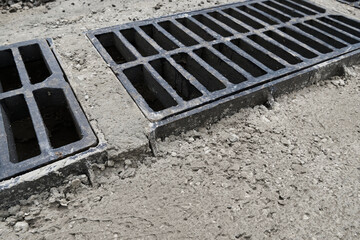 New rainwater grate on the road or sidewalk, installation in concrete. City sewage system for draining water during heavy rain