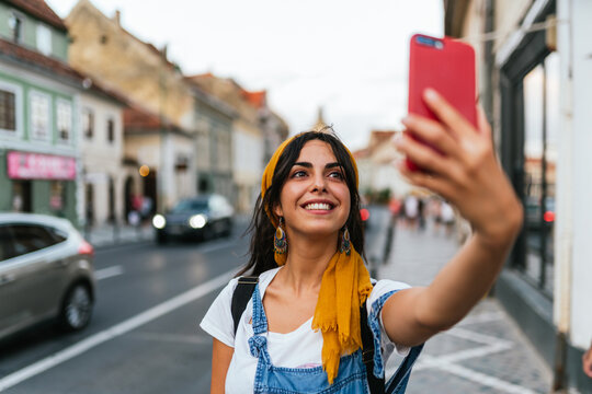 Close up of a beautiful smiling young woman taking selfie.