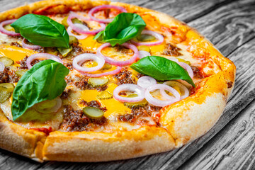 Pizza with Mozzarella cheese, Bolognese sauce, minced meat and vegetables. Italian pizza on wooden background.