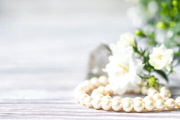 Fototapeta na wymiar Beautiful white pearl necklace with white flowers.