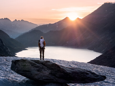 female alpinist overlooking glacial landscape at sunrise