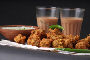 Crispy pakoras, delicious street food, favourite indian snack in monsoon served with Hot Tea