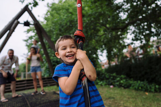 Happy little boy riding on cable in park