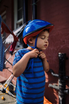 Child putting on bike helmet