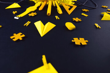 A concept on the subject back to school. The student's yellow stationery on a black background