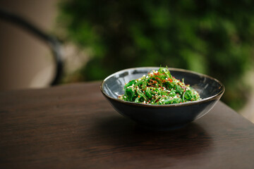 Green chuka seaweed salad in a black bowl