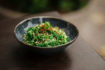 Green chuka seaweed salad in a black bowl
