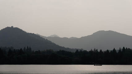 A light boat on a lake which has a lot of mountains surrounding it
