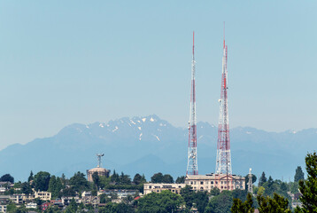 Obraz premium Partial view of the Queen Anne neighborhood in Seattle with its radio towers and Olympic Mountains in the back.