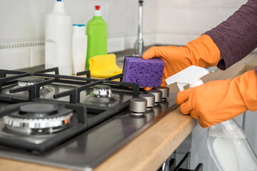person with glove and cleaning set wash kitchen furniture. protect yourself