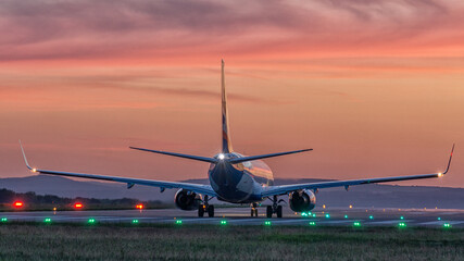 Naklejka premium airplane landing at sunset