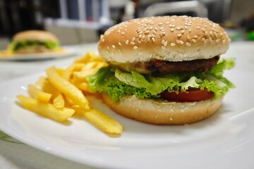 Lanche de hambúrguer feito em casa com batatas fritas. X-salada caseiro. Delicioso lanche com...