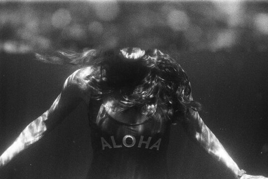 Underwater potrait of woman in swimsuit saying aloha