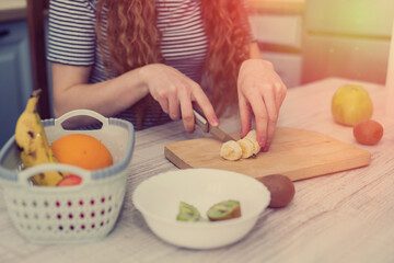 Happy young woman prepare doing fruits salad for diet in kitchen, healthy food