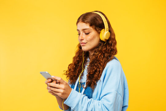 Beautiful Young Woman Portrait Over Yellow Background.