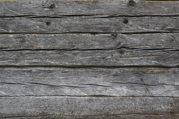 Obraz premium Vintage rustic background. House wall in the village. Large, untreated gray logs in a horizontal arrangement.