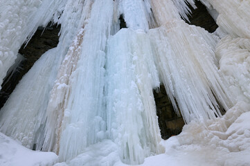 Wide angle abstract wall of ice with icicles and snow on the cliff at Tiffany Falls Ontario