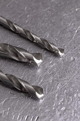 Concept metalworking. Metal drill bits on a metal old background with copy space.