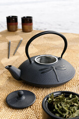 Obraz na płótnie Canvas Japanese cast iron teapot with tea leaves on a cold winter day