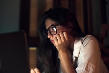 Woman at night working on laptop