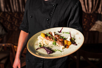 chef with tasty dish in hands