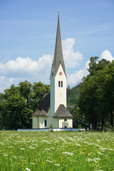 Fototapeta na wymiar Church in the mountains with a meadow in the foreground in Bavaria